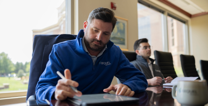 An investment banker taking notes on his tablet