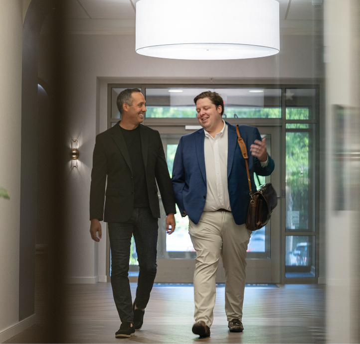 Two coworkers smiling as they enter the office