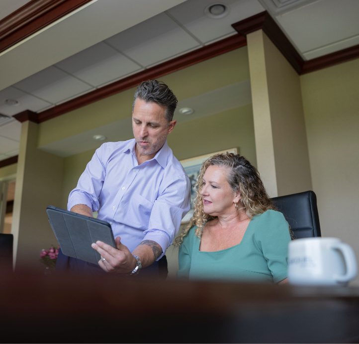 A man showing his colleague an email on his tablet