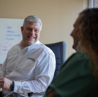 An investment banker smiling at his colleague